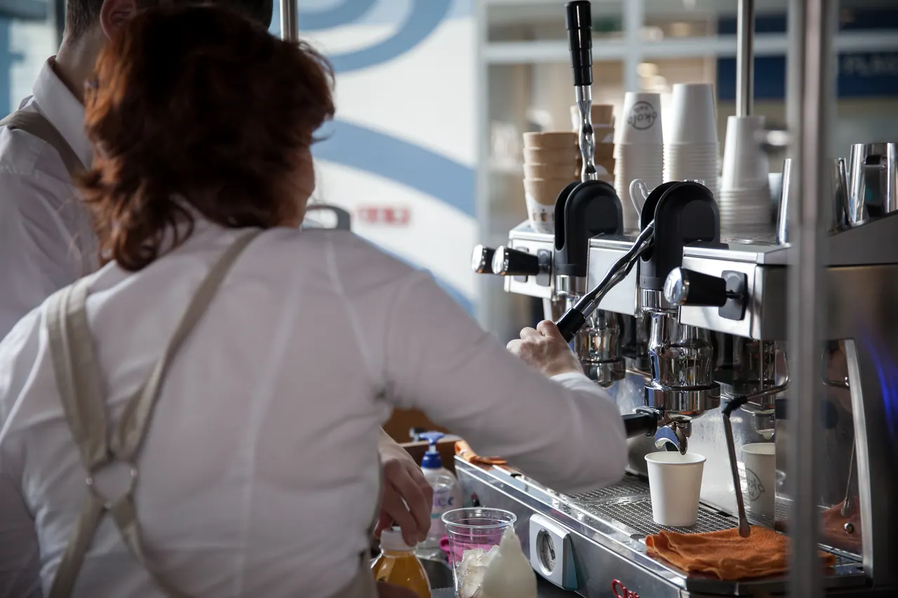 Baristka připravuje kávu u kávovaru na coffee biku