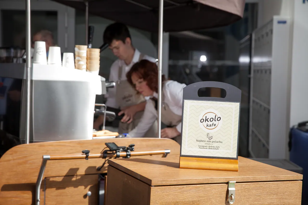 Dřevěná cedulka s nápisem „Najdete nás počuchu" na coffee biku